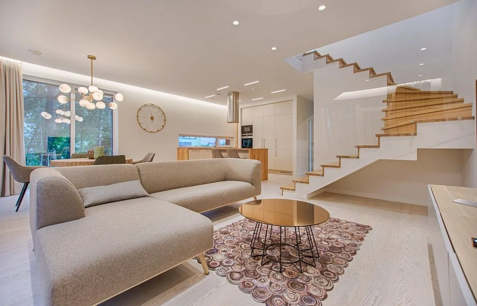 Living room with a staircase, seating and adjoining kitchen