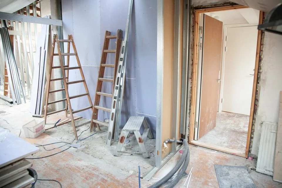 Interior undergoing building repair with ladders and exposed walls